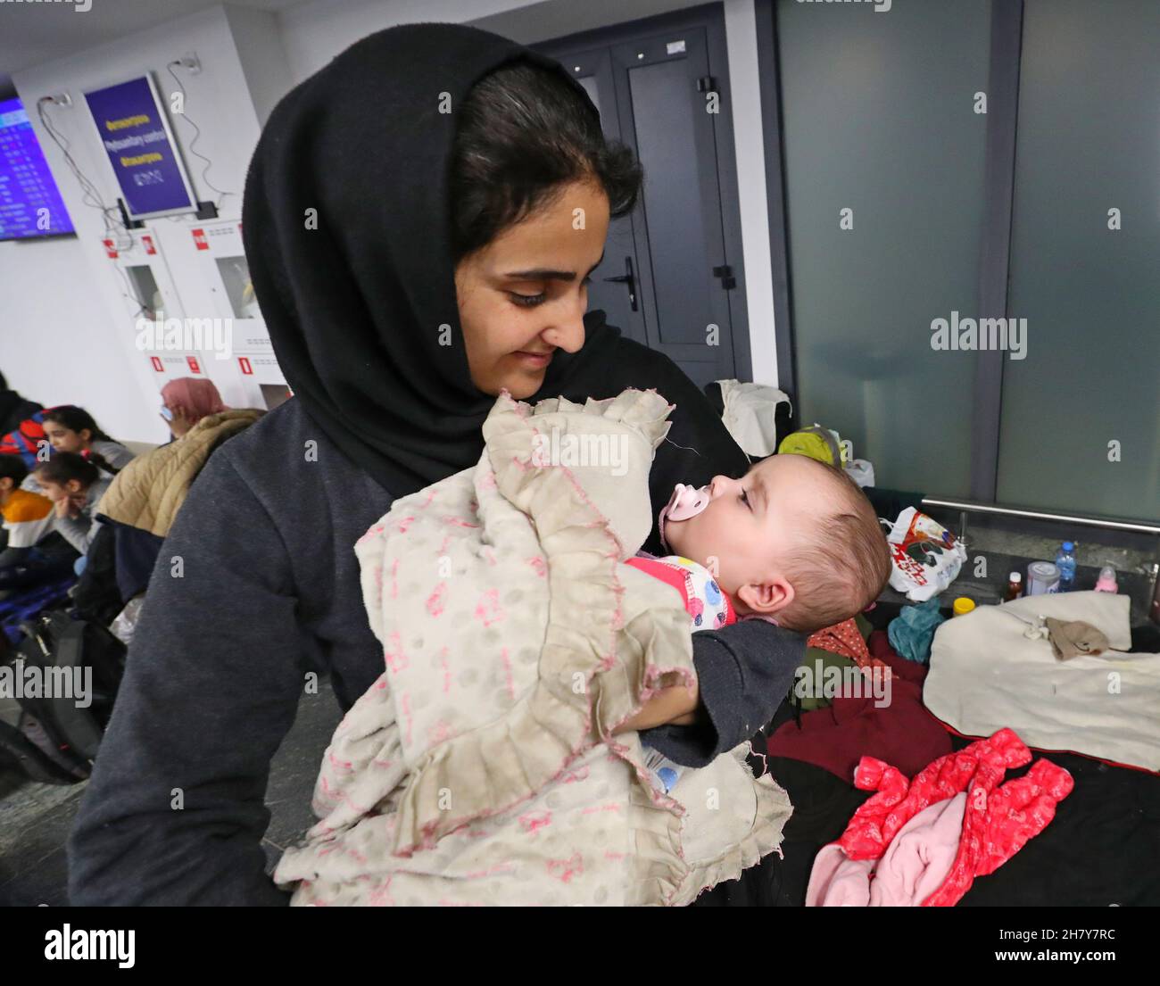 Minsk, Bielorussia. 25 Nov 2021. I migranti iracheni bloccati attendono di tornare in Iraq all'aeroporto internazionale di Minsk, in Bielorussia, il 25 novembre 2021. Il Ministero degli Esteri iracheno ha detto giovedì che ha evacuato 617 migranti bloccati in Bielorussia, la maggior parte dei quali sono donne, bambini e anziani. Migliaia di migranti si sono riuniti sul lato bielorusso del confine con la Polonia, nel tentativo di entrare in Polonia e poi in Germania per chiedere asilo nei paesi europei. Credit: Henadz Zhinkov/Xinhua/Alamy Live News Foto Stock
