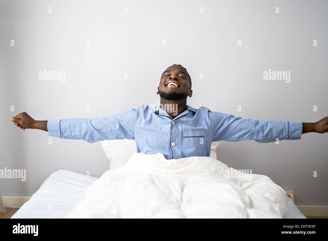 Giovani Sorridenti Africano di svegliarvi in camera da letto Foto Stock