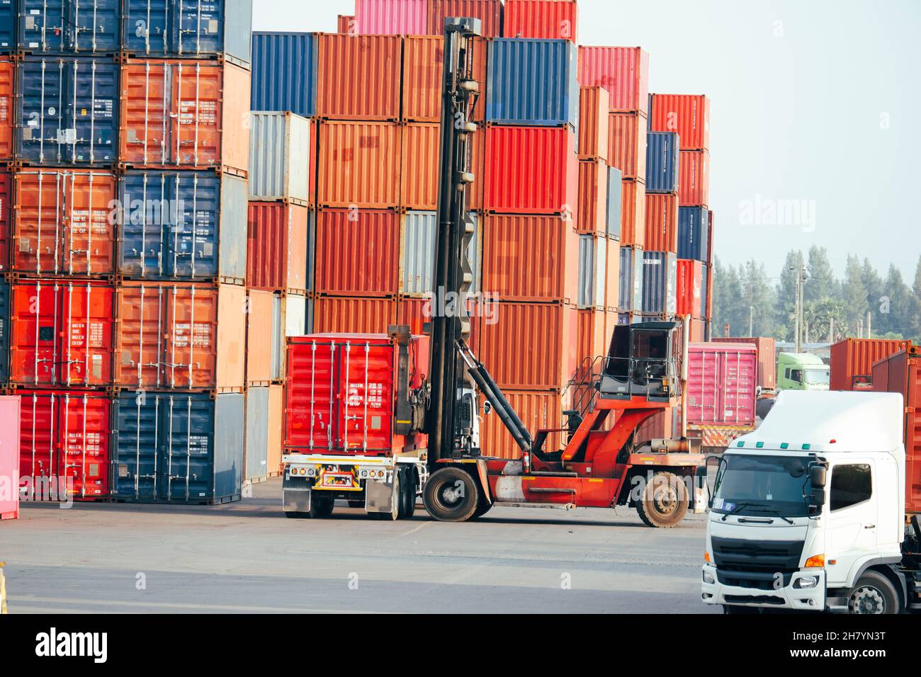 Carrello elevatore a forche container che sposta i contenitori nei carrelli Foto Stock