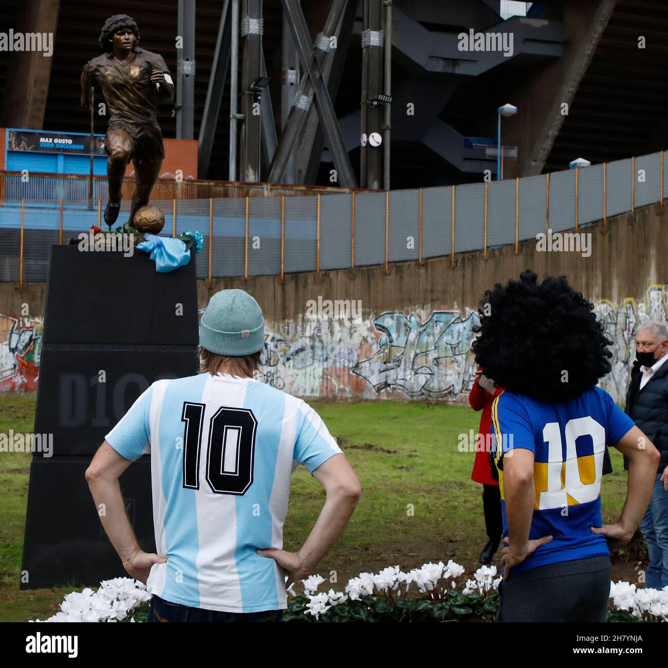 Napoli, Italia. 25 Nov 2021. I tifosi rendono omaggio alla statua dell'icona del calcio argentino Diego Maradona di fronte allo stadio Diego Armando Maradona nel primo anniversario della sua morte a Napoli, 25 novembre 2021. Credit: Str/Xinhua/Alamy Live News Foto Stock