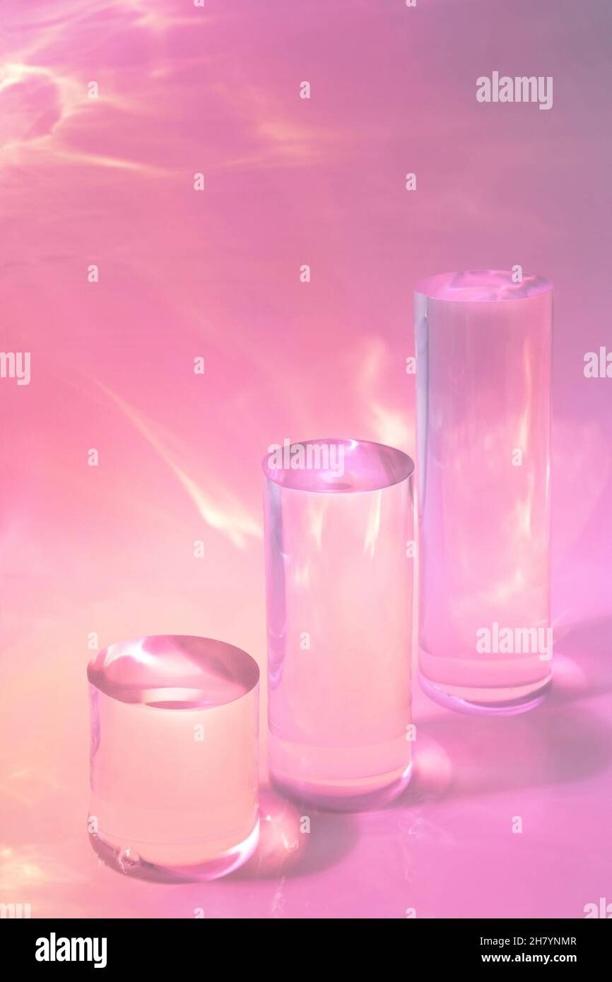 tre podi in vetro chiaro su sfondo rosa pastello Foto Stock