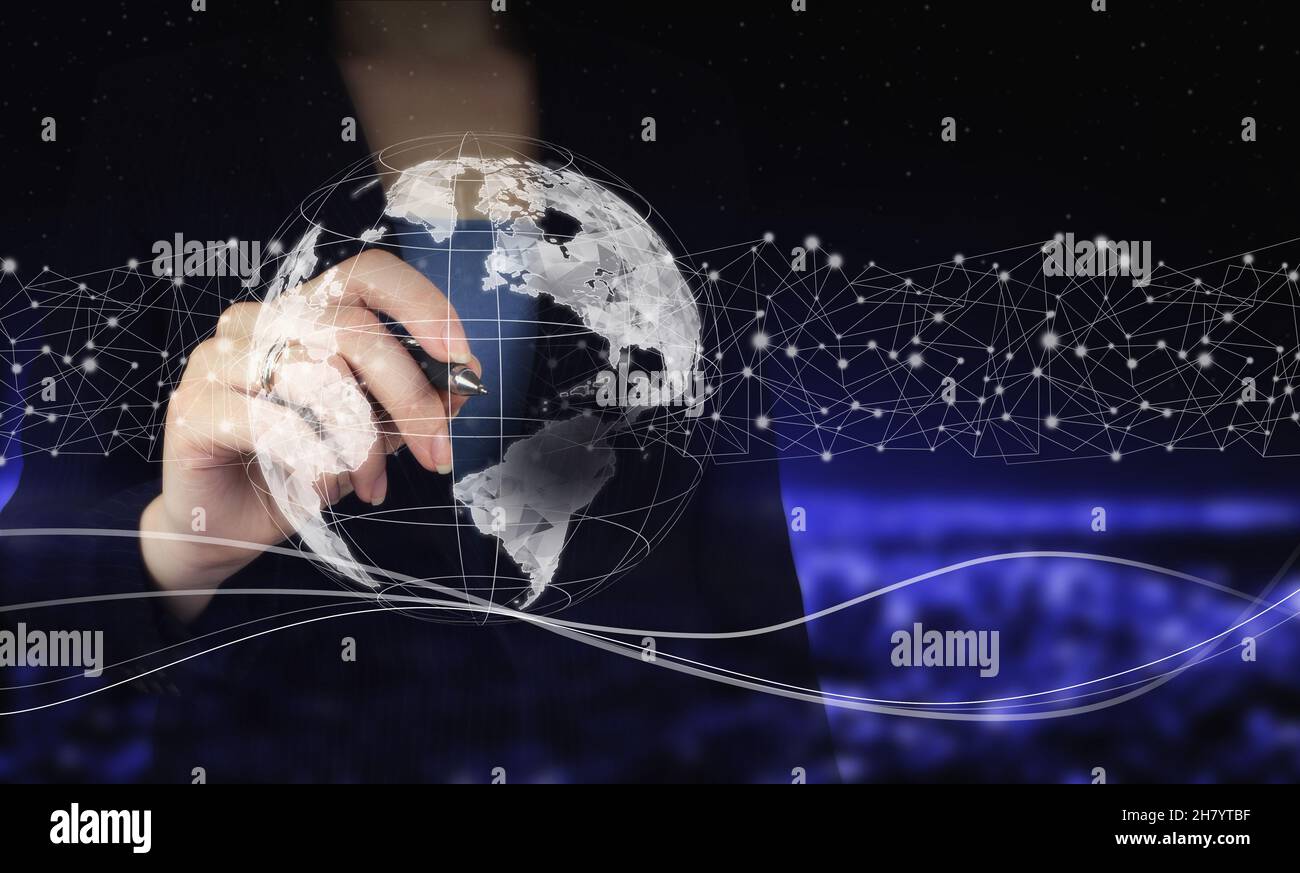 Concetto di tecnologie globali. Mano che tiene la penna grafica digitale e disegno digitale ologramma mondo, terra, mappa, globo segno sulla città scuro sfocato backgrou Foto Stock
