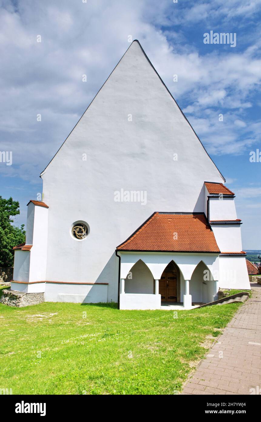 Chiesa gotica con bel cielo blu, erba verde e giorno di sole. Chiesa di San Giorgio in Slovacchia. Bellissimo sfondo con l'architettura. Foto Stock