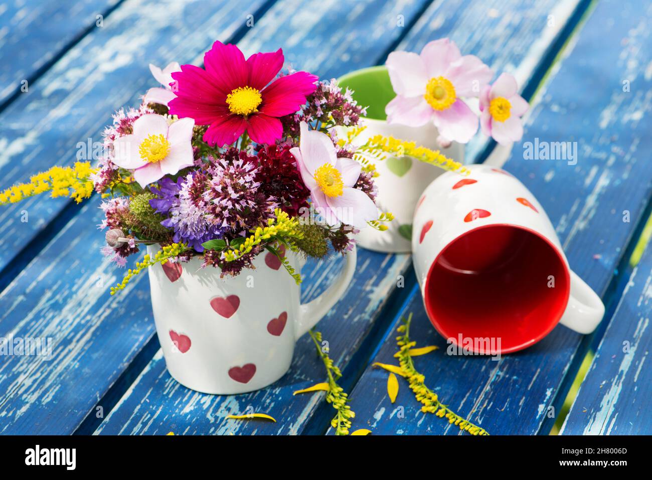 Tazze di caffè con cuori e fiori in giardino Foto stock - Alamy
