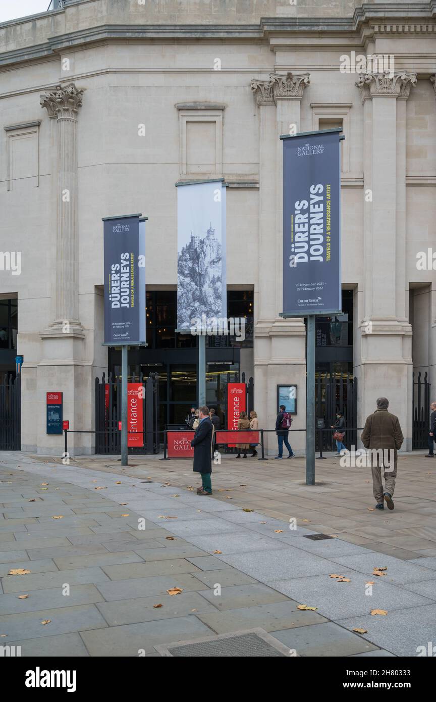 Le persone si accodano per entrare nella National Gallery Sainsbury Wing. Le bandiere di pubblicità appendono all'esterno sulle colonne libere in piedi. Londra, Inghilterra, Regno Unito Foto Stock