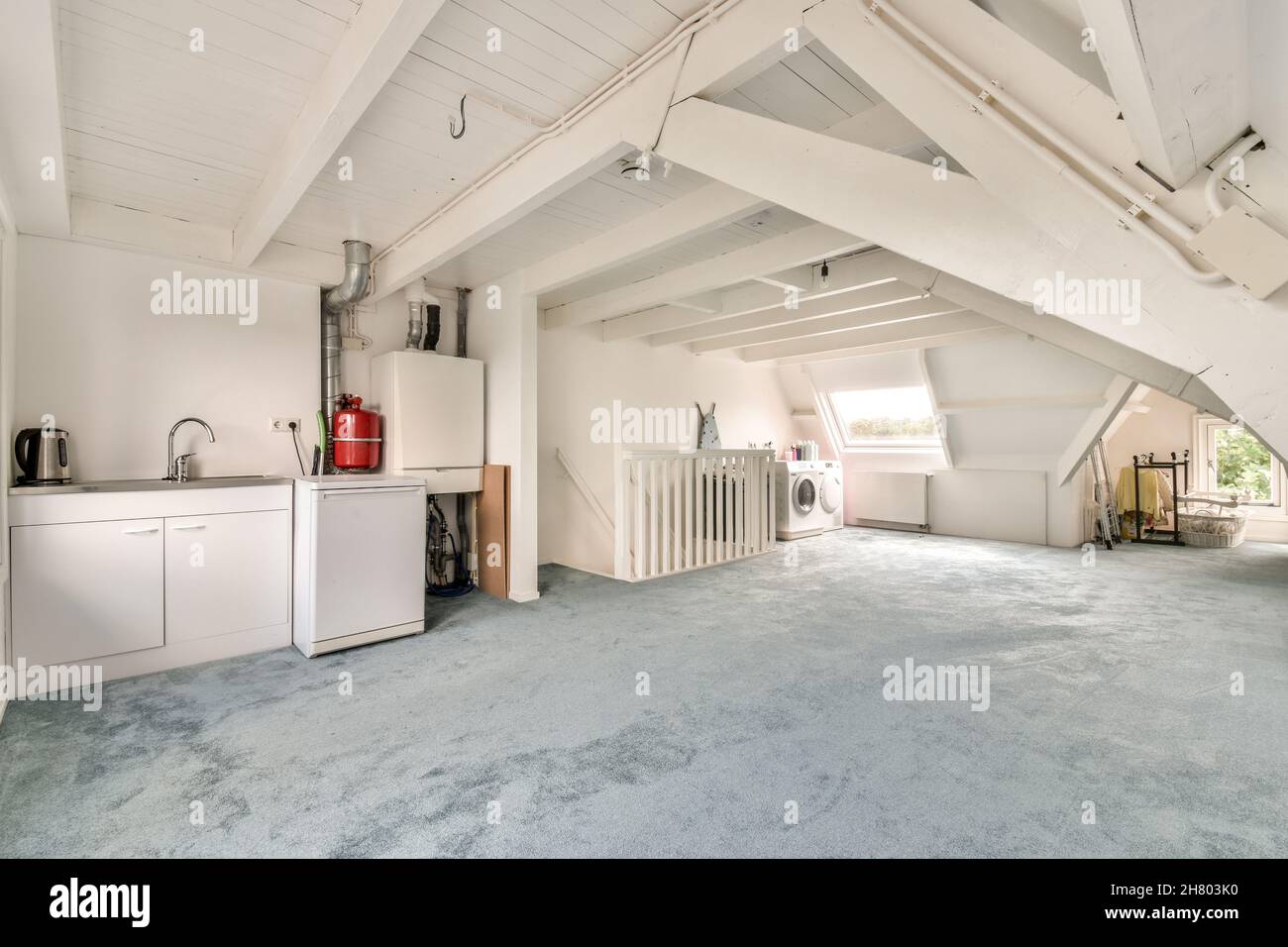 All'interno di una spaziosa mansarda con impianto di riscaldamento con tubi lavello e lavatrice in un cottage sobborgo Foto Stock