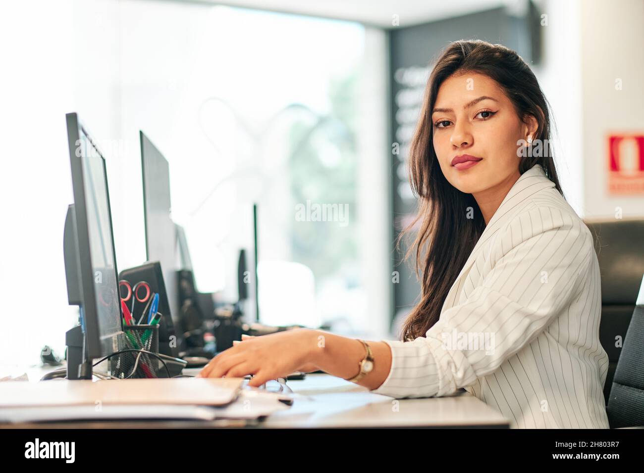 giovane donna d'affari latina che lavora nel suo ufficio Foto Stock