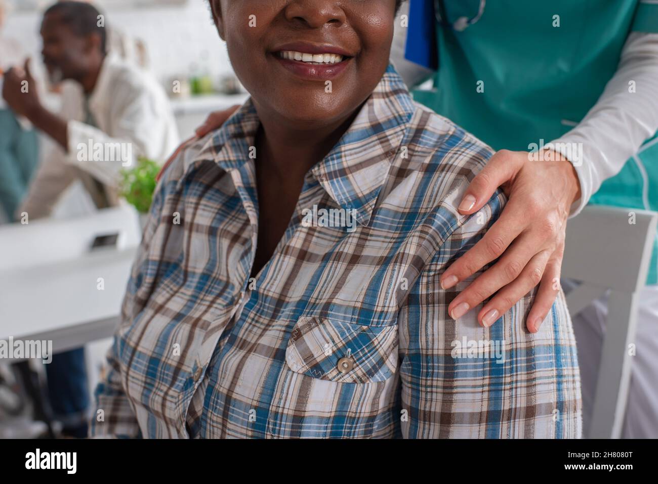 Infermiera che sorride paziente afroamericano in casa di cura Foto Stock