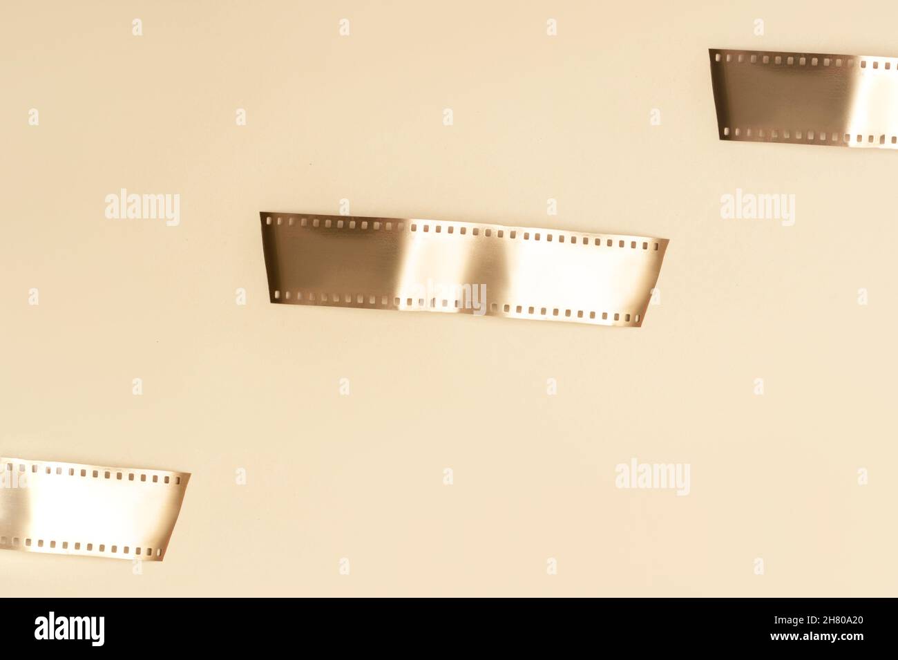 Strisce di film in oro su sfondo beige. Poster a tema multimediale orizzontale, biglietti d'auguri, intestazioni, sito Web e app Foto Stock
