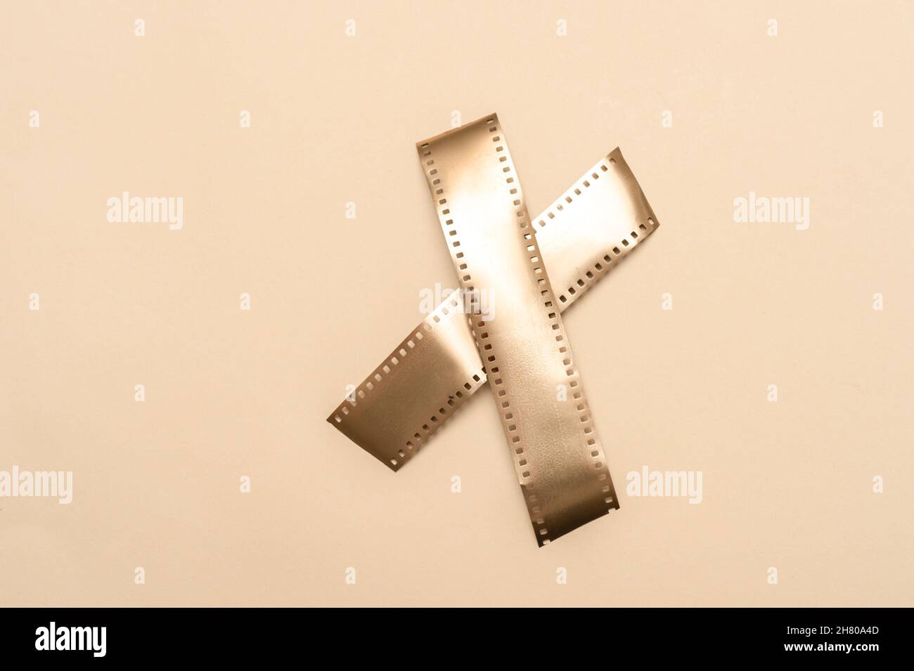 Strisce di film in oro su sfondo beige. Poster a tema multimediale orizzontale, biglietti d'auguri, intestazioni, sito Web e app Foto Stock