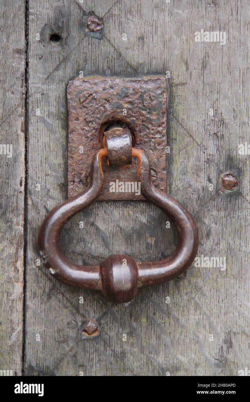 Un Rusty Metal Door Knocker su una grande porta di legno. Foto Stock