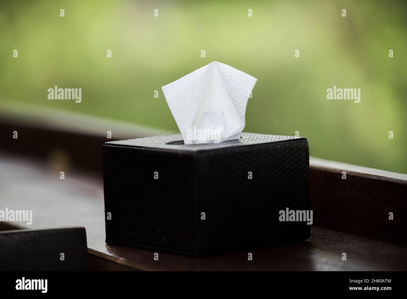 Scatola di tessuto nera su barra di legno marrone. Foto Stock