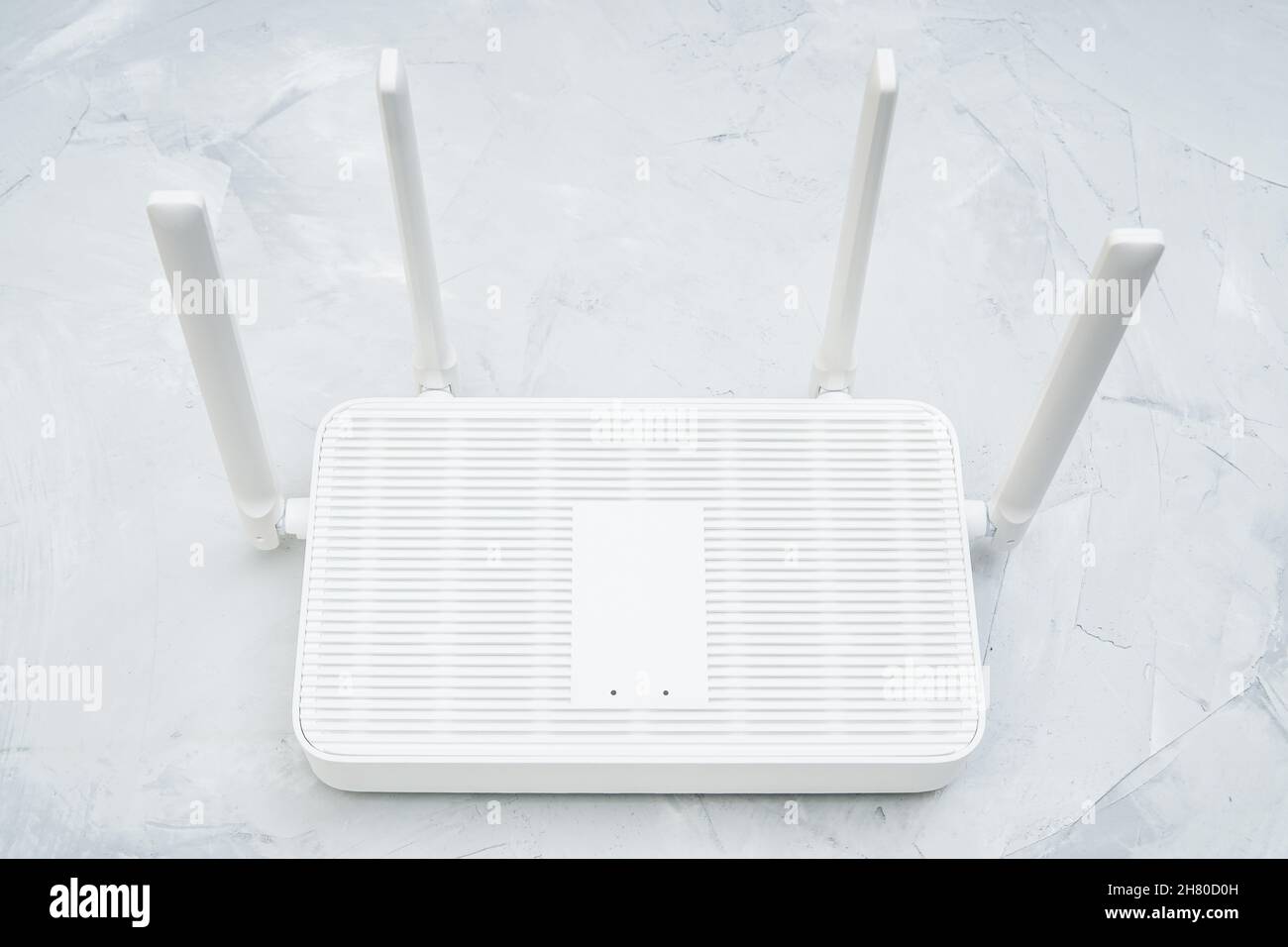 Vista dall'alto di un router wi-fi 6 dual band con quattro antenne posizionate su un tavolo in cemento Foto Stock
