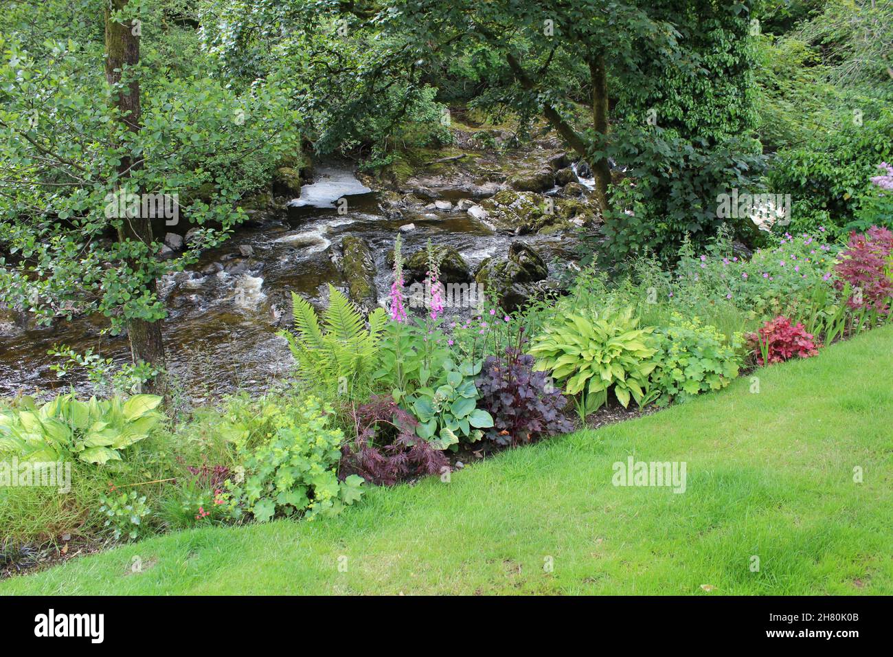 Prato con bordo del giardino che conduce al fiume Cree (Scozia) Foto Stock