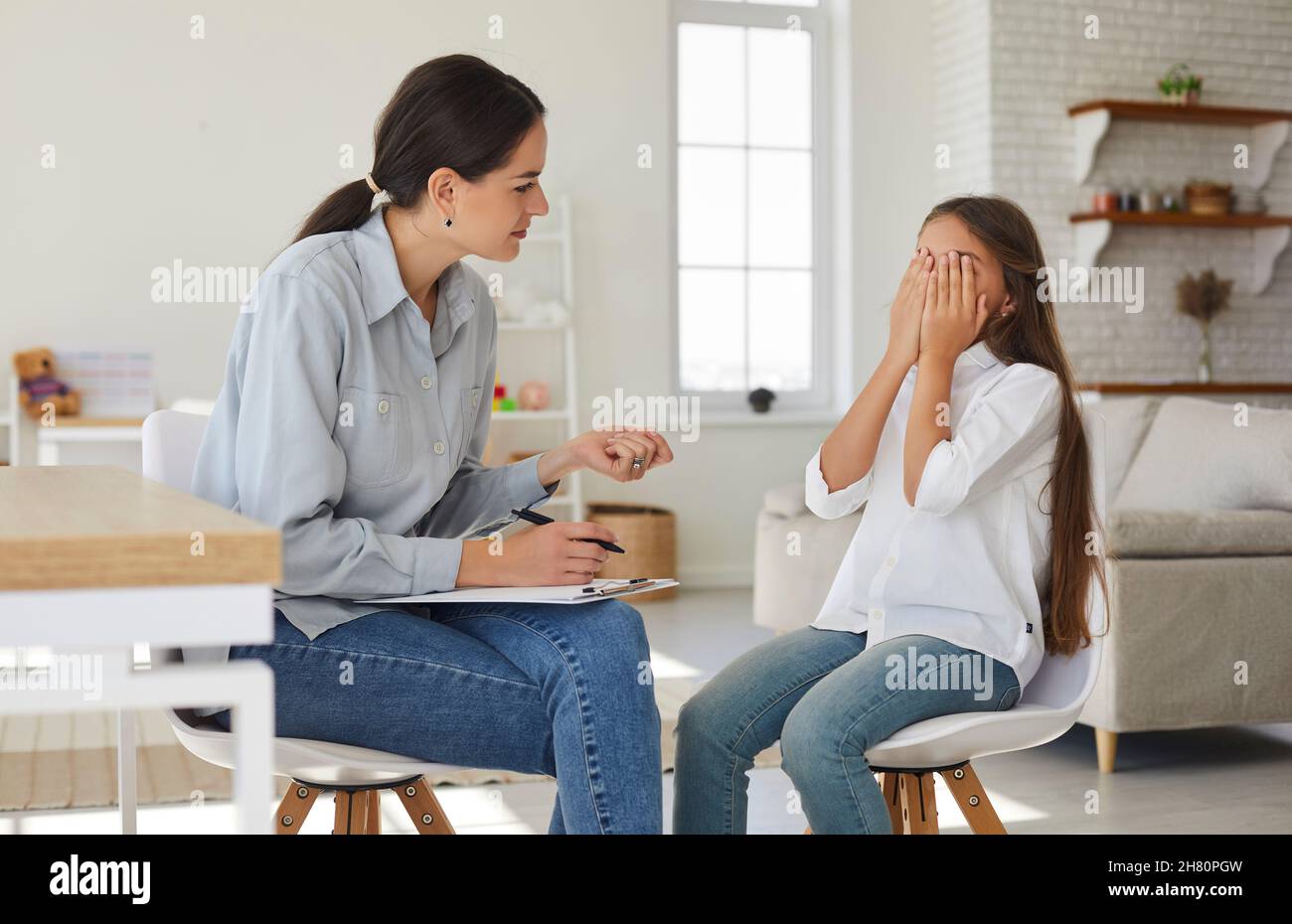 Consigliere terapista o psicologo cercando di aiutare un bambino triste, stressato, piangente Foto Stock