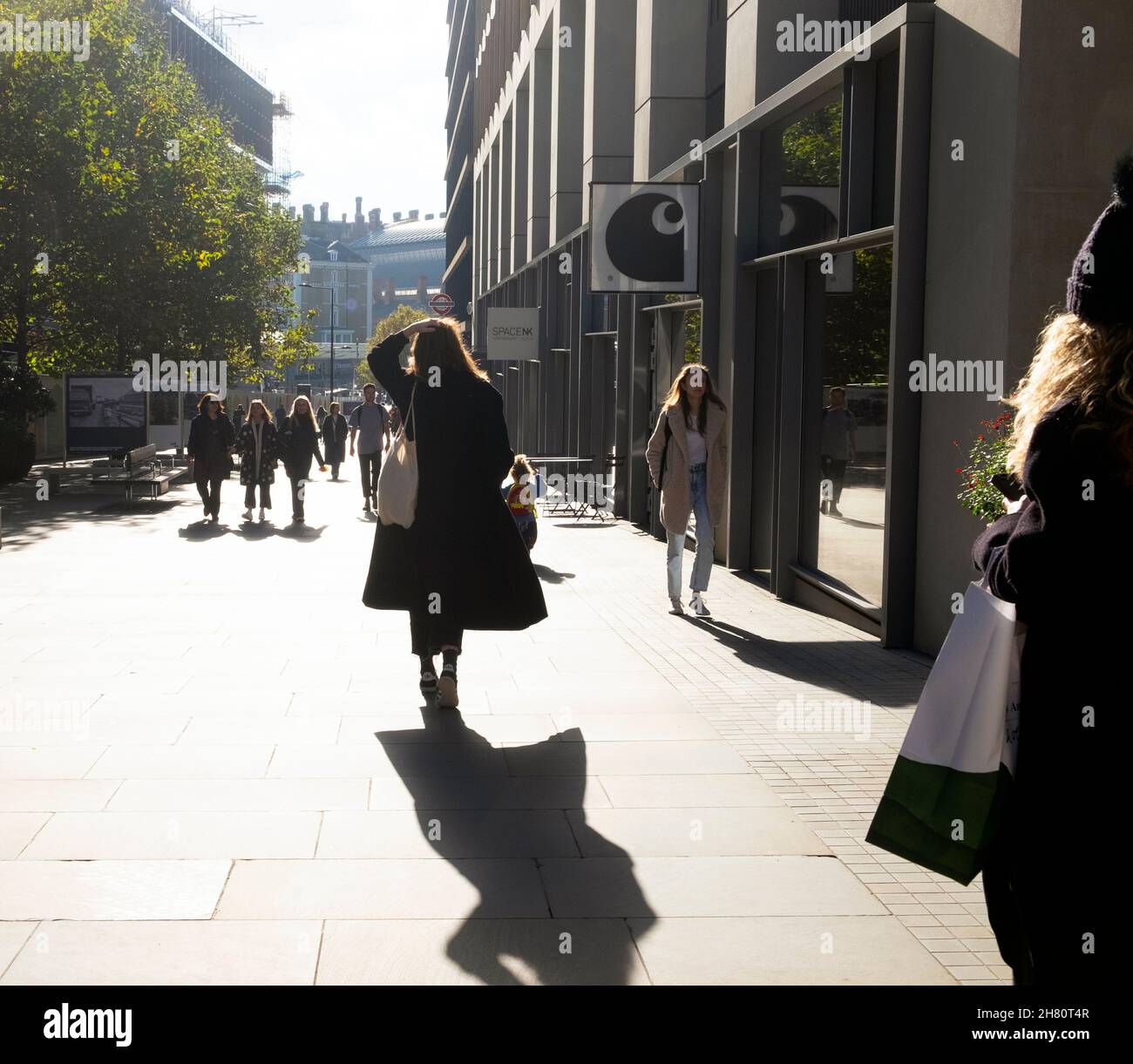 Giovane donna posteriore vista indietro persone che camminano lungo Kings Boulevard nella zona di Kings Cross St Pancras di Londra N1 nell'autunno 2021 Inghilterra KATHY DEWITT Foto Stock