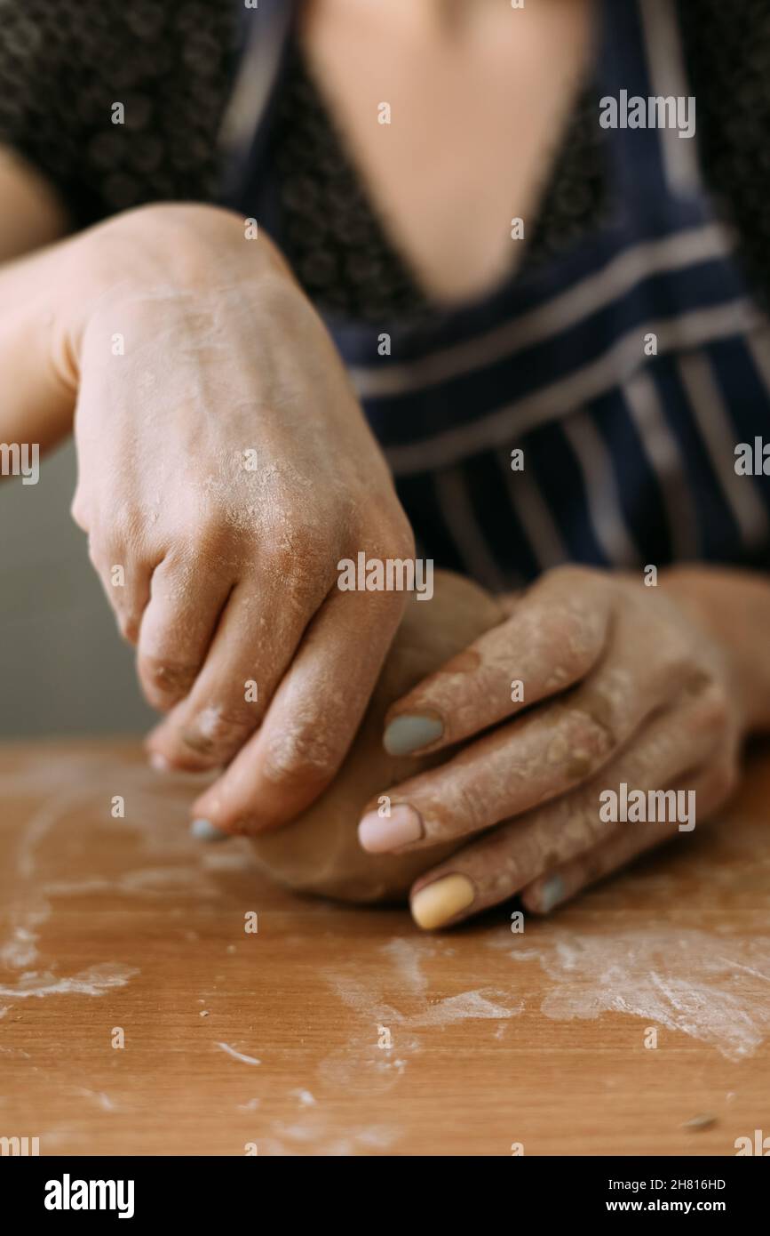 Donna vasaio lavora con argilla, mani di artigiano primo piano, scolpisce una ciotola o vaso. Il concetto di lavorare con argilla Foto Stock
