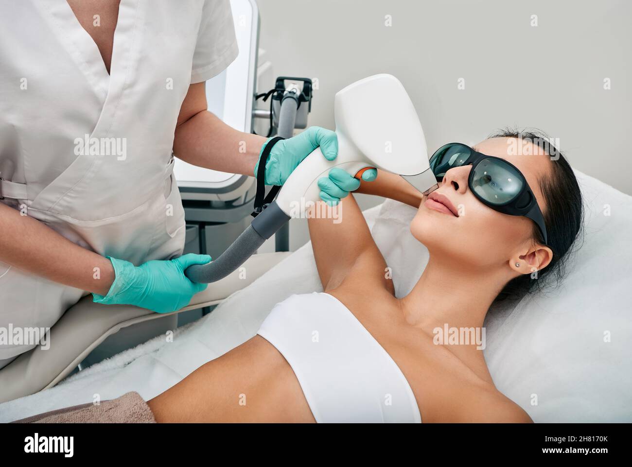Rimozione dei peli del laser facciale. Bella donna durante la rimozione dei capelli laser e l'epilazione laser alla zona delle labbra sul viso Foto Stock
