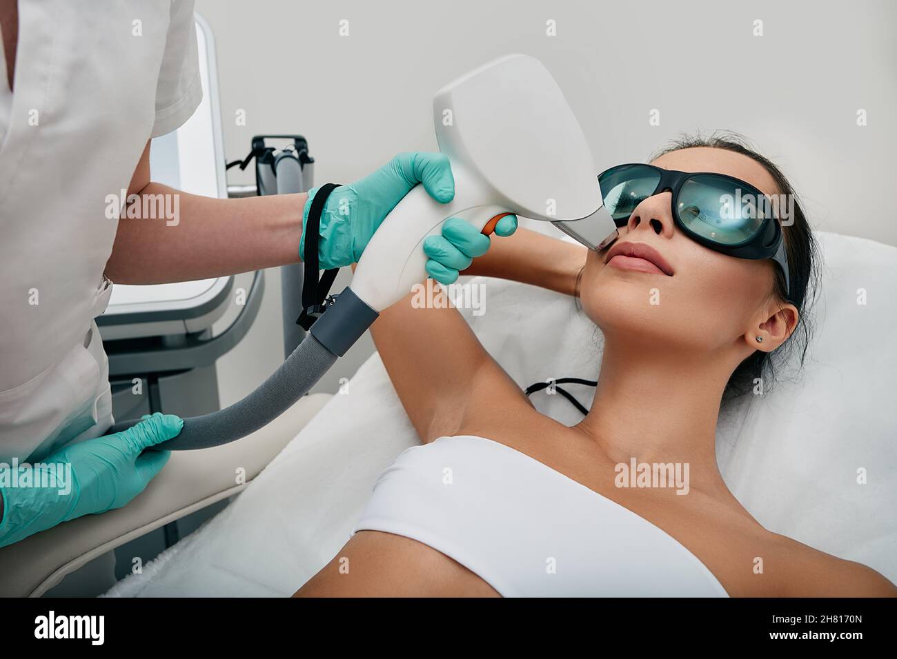 Donna brunette ottenere la rimozione dei capelli laser sul suo viso, epilazione laser alla zona delle labbra. Rimozione dei capelli del laser facciale Foto Stock