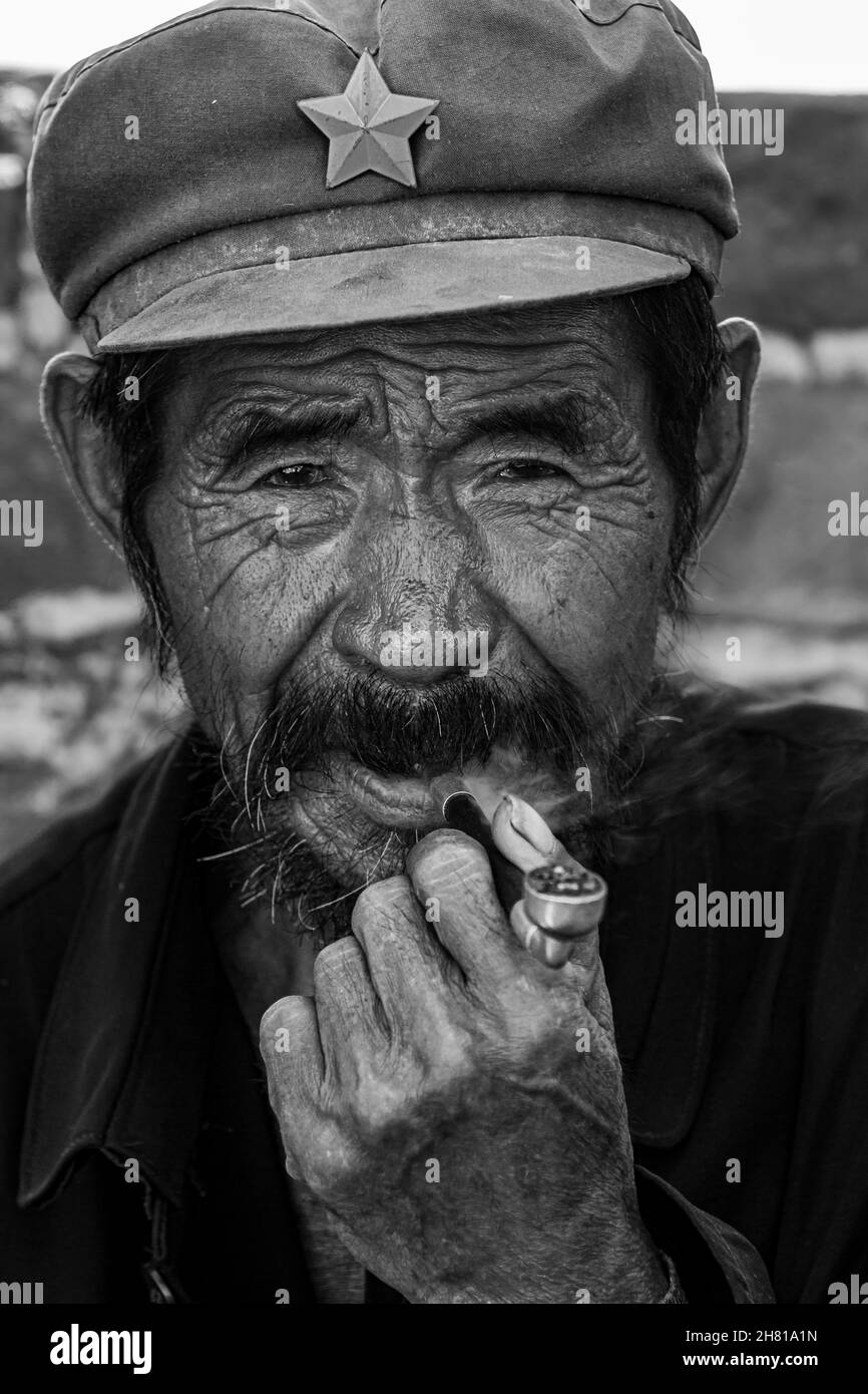 Un uomo mongolo sta fumando una pipa Foto Stock