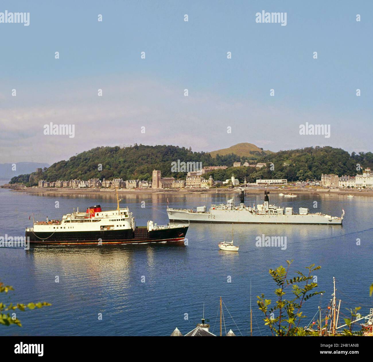MV Columba passa l'HMS Leoprad sulla strada per il molo della ferrovia di Oban degli anni '70 Foto Stock