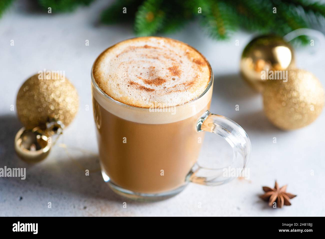 Coppa di Natale di cappuccino caffè con cannella vicino albero di Natale. Caffè caldo invernale accogliente Foto Stock