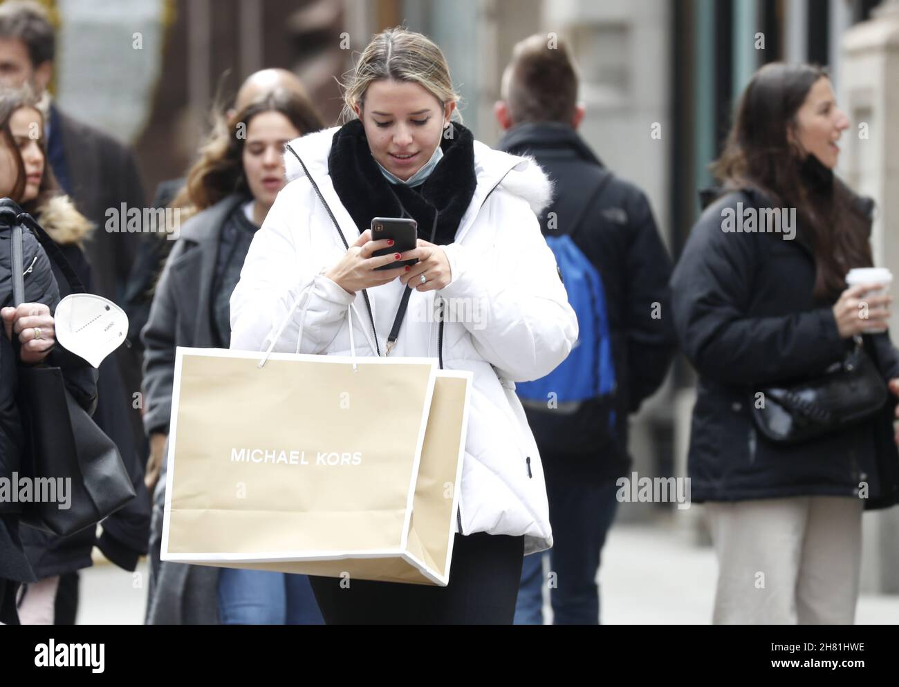New York, Stati Uniti. 26 novembre 2021. Un acquirente tiene una borsa  Michael Kors mentre cammina sulla Fifth Avenue il Black Friday a New York  City venerdì 26 novembre 2021. Per oltre