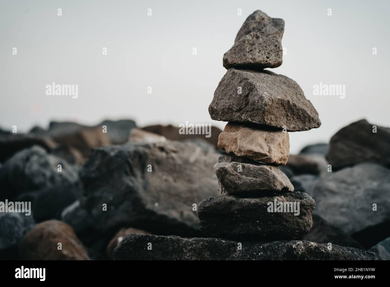 Primo piano di una piramide da grandi e piccoli pezzi di pietre in mezzo alle rocce in una giornata buia Foto Stock