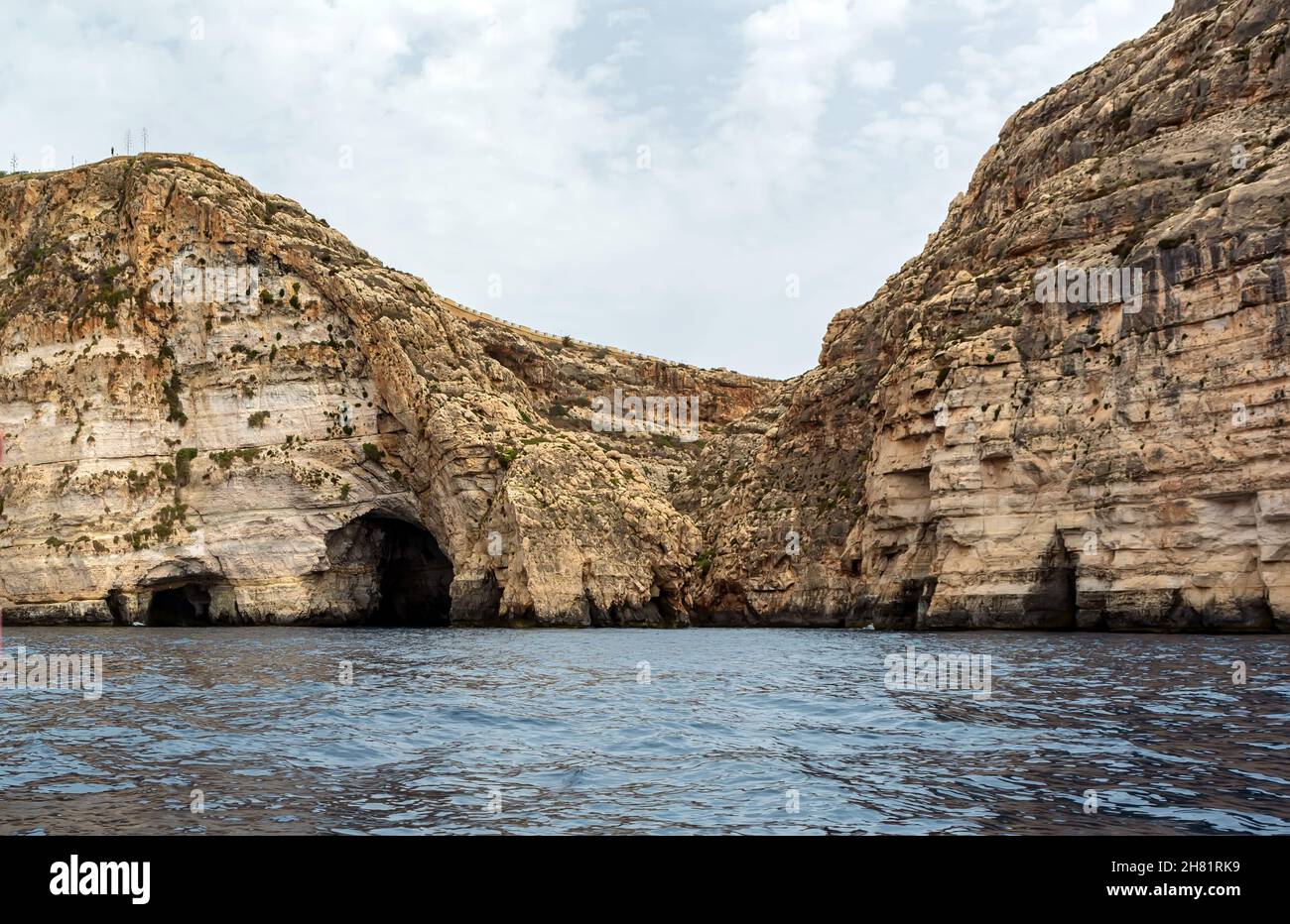 Bordi rocciosi dell'insenatura di Wied iż-Żurrieq vicino alla Grotta Azzurra, Malta, che si stacca dal Mar Mediterraneo e si illumina al sole del mattino. Formazioni rocciose con Foto Stock