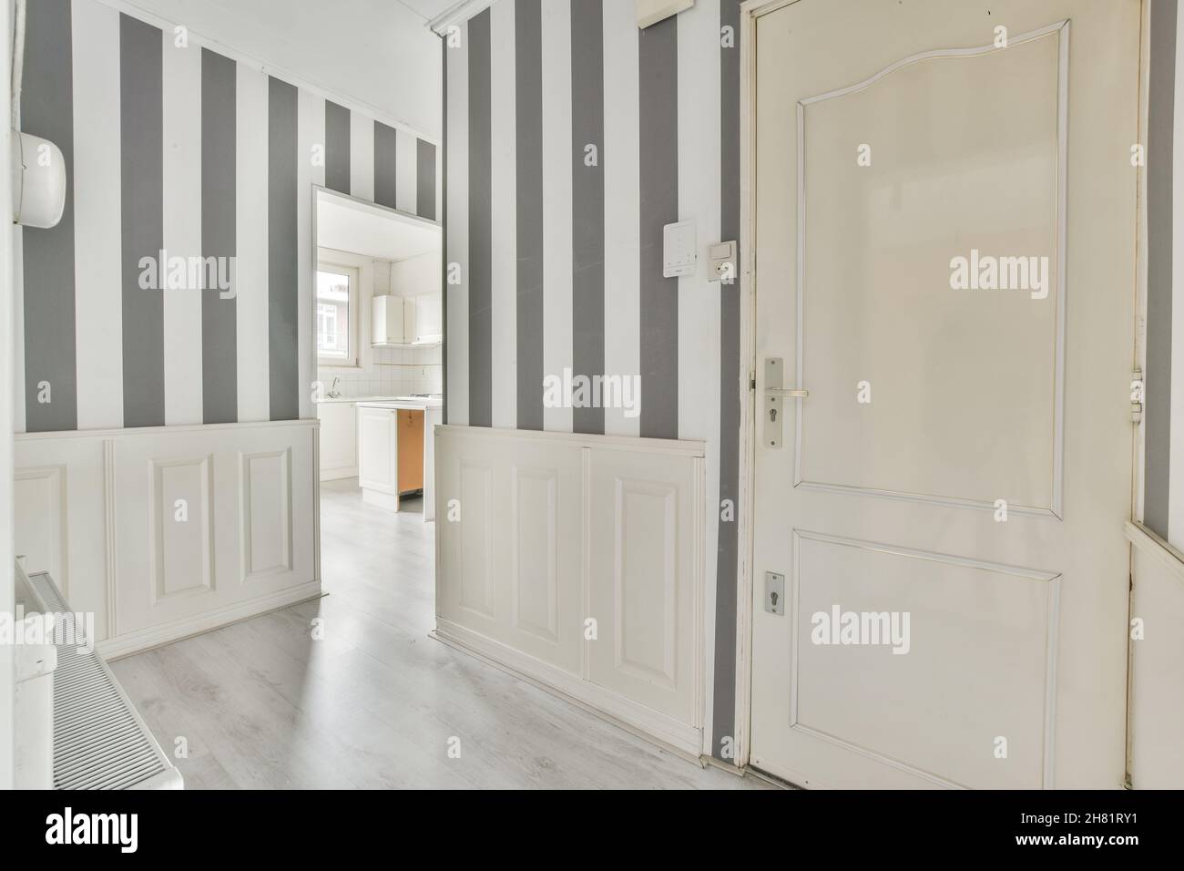 Corridoio di un moderno appartamento con carta da parati a strisce bianche nere Foto Stock