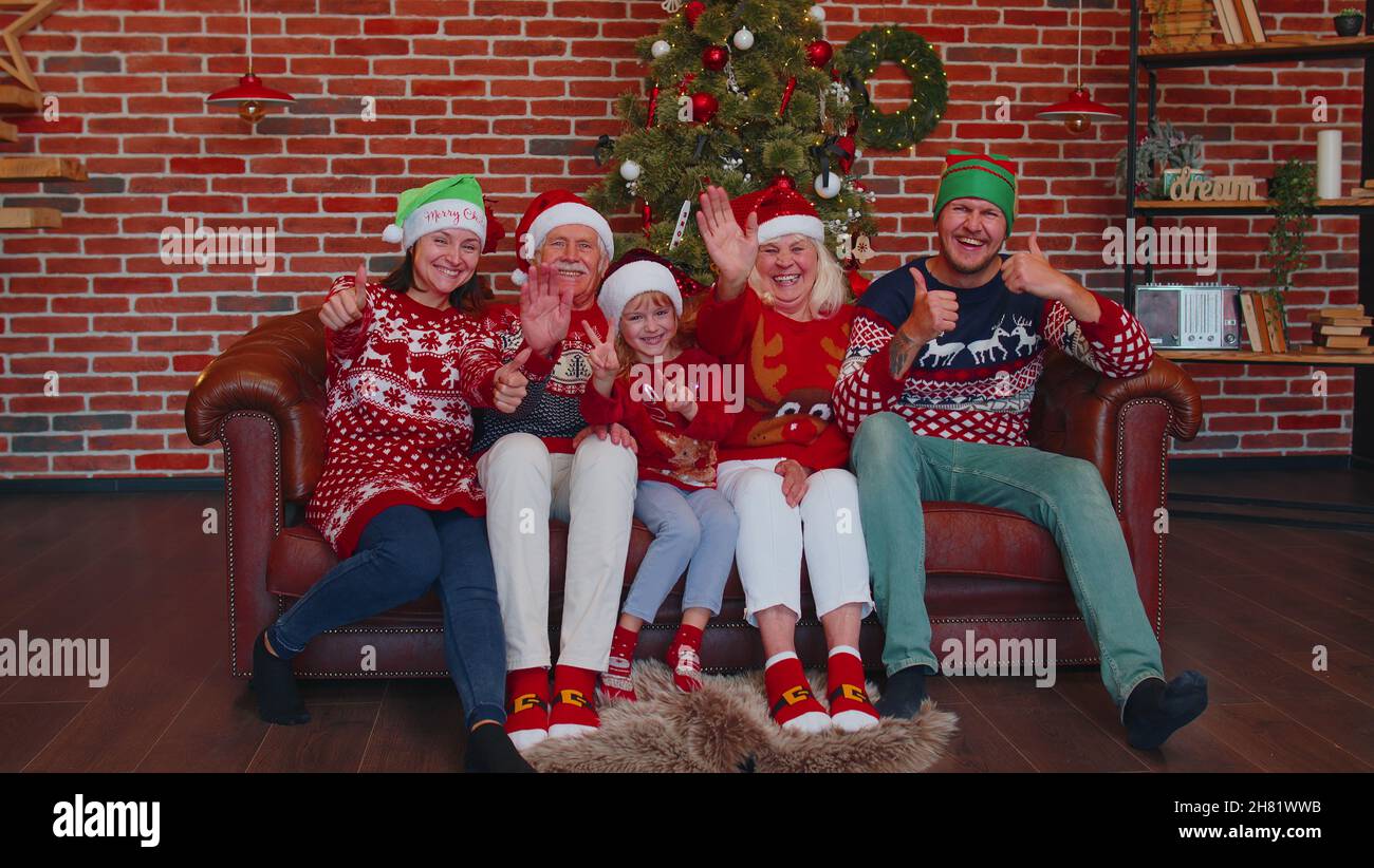 Risate la famiglia che sventola le mani ciao, ciao, saluto mentre si prende selfie su smartphone a casa di Natale Foto Stock