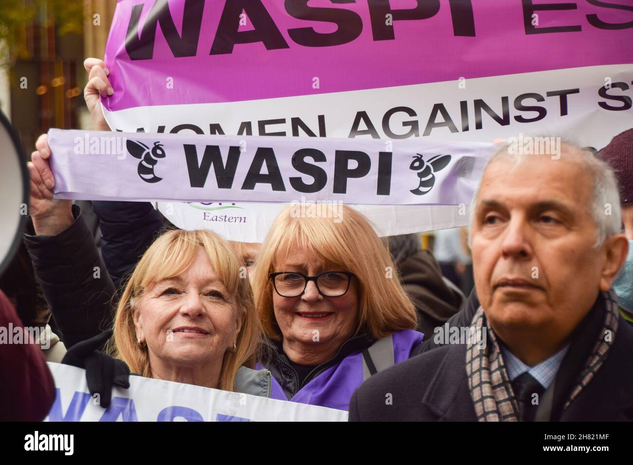 Londra, Regno Unito. 26 novembre 2021. I manifestanti tengono striscioni WASPI (Women Against state Pension Disequality) durante la dimostrazione fuori Downing Street.i dimostranti si sono riuniti fuori dalle Camere del Parlamento e hanno marciato a Downing Street per consegnare una lettera a Boris Johnson, chiedendo azione sulle morti invernali in eccesso. Decine di migliaia di persone, in particolare le più antiche e le più povere, muoiono ogni anno a causa delle case fredde e dell'incapacità di permettersi il riscaldamento. Credit: SOPA Images Limited/Alamy Live News Foto Stock