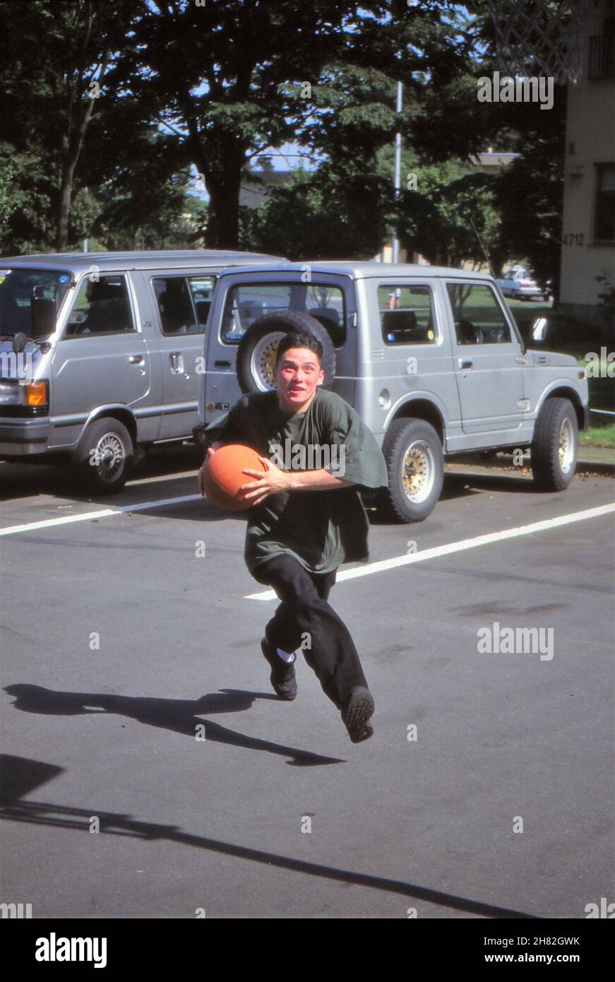 OCEAN SPRINGS, STATI UNITI d'AMERICA - 22 novembre 2021: L'uomo corre con il basket attraverso il parcheggio per fare un cerchio per fare un Sho Foto Stock