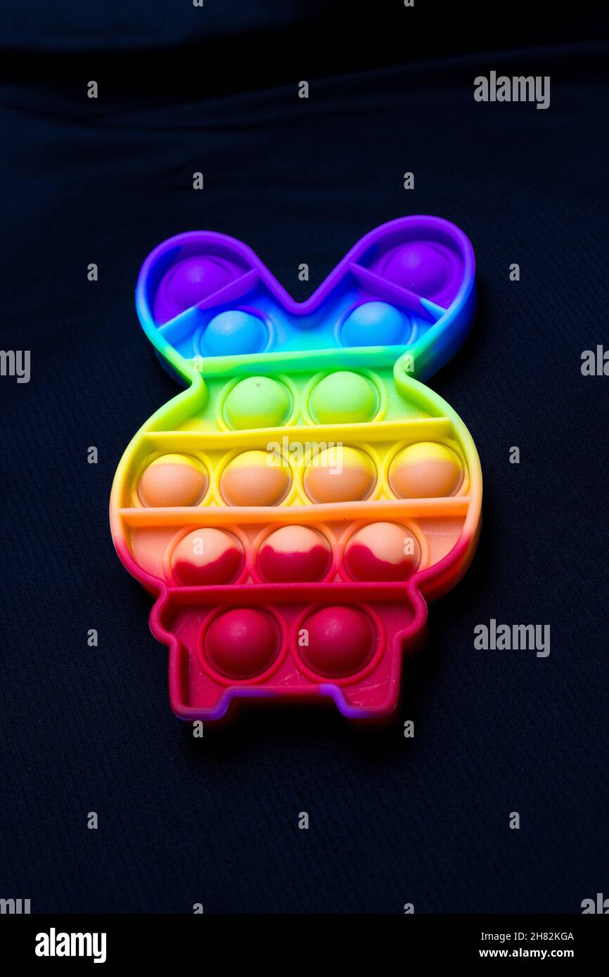 Giocattolo colorato pop it a forma di coniglio su sfondo nero a Rio de Janeiro. Foto Stock