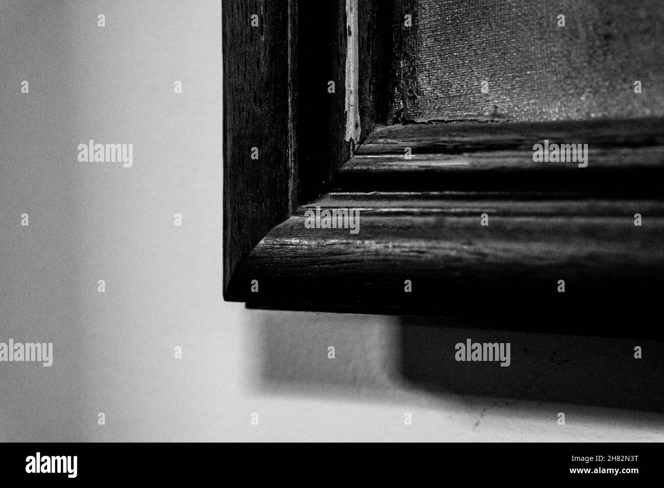 Primo piano immagine in scala di grigi di un angolo di cornice in legno sulla parete. Foto Stock