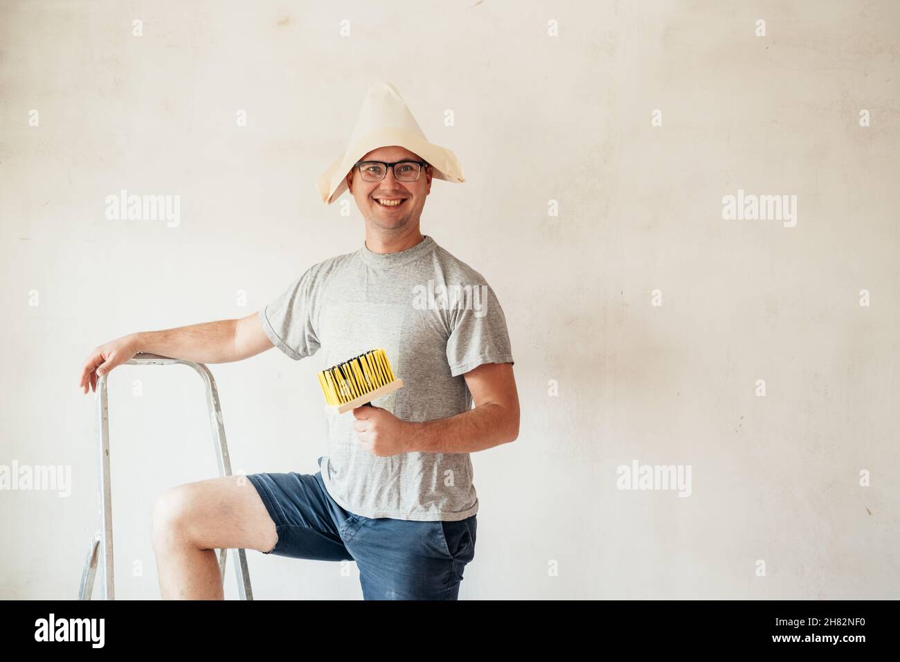 Il lavoratore del handyman domestico di miglioramento del gasterer fa le riparazioni. ristrutturazione fai da te nuovo muro di pittura casa. Foto Stock