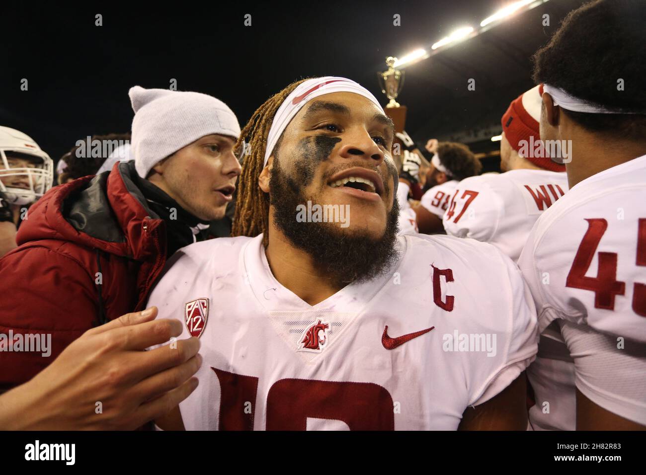 Seattle, Stati Uniti. 26 novembre 2021. CORREZIONE 26 novembre 2021: I Washington state Cougars Jahad Woods si fanno strada attraverso la folla per tenere il trofeo di Apple Cup dopo una partita tra i Washington state Cougars e Washington Huskies all'Alaska Airlines Field di Seattle, WA per la 113esima Apple Cup. I Cougars hanno vinto il 40-13. Sean BrownCSM Credit: CAL Sport Media/Alamy Live News Foto Stock