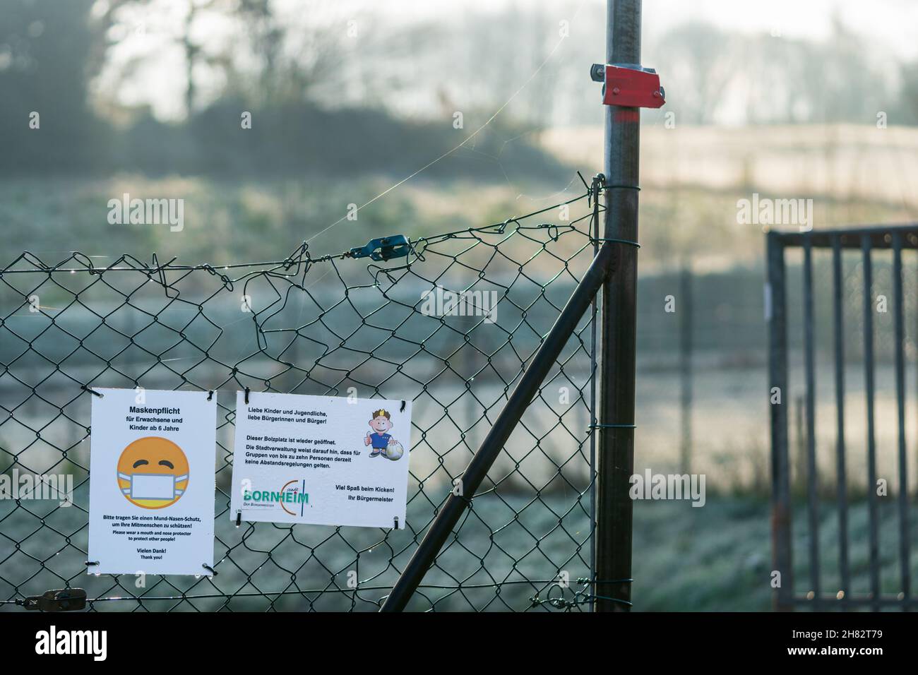 Bornheim, Germania - 10 dicembre 2020: Due cartelli sulla recinzione a catena al campo di calcio con il testo tedesco 'il campo di Soccer è di nuovo aperto. Nessuna regola di distanziamento. Foto Stock