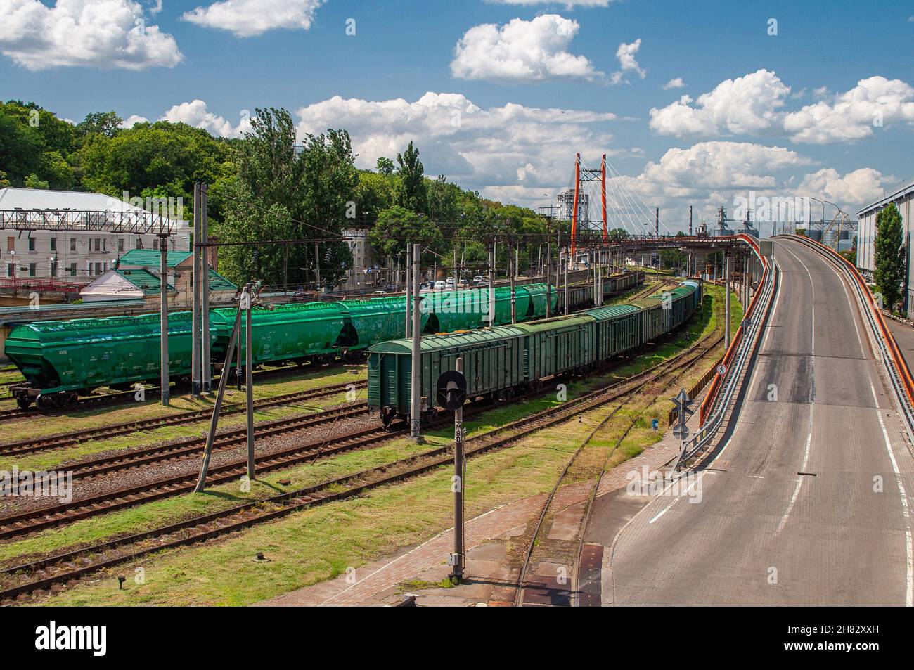 Ferrovia con vagoni merci accanto all'autostrada Foto Stock