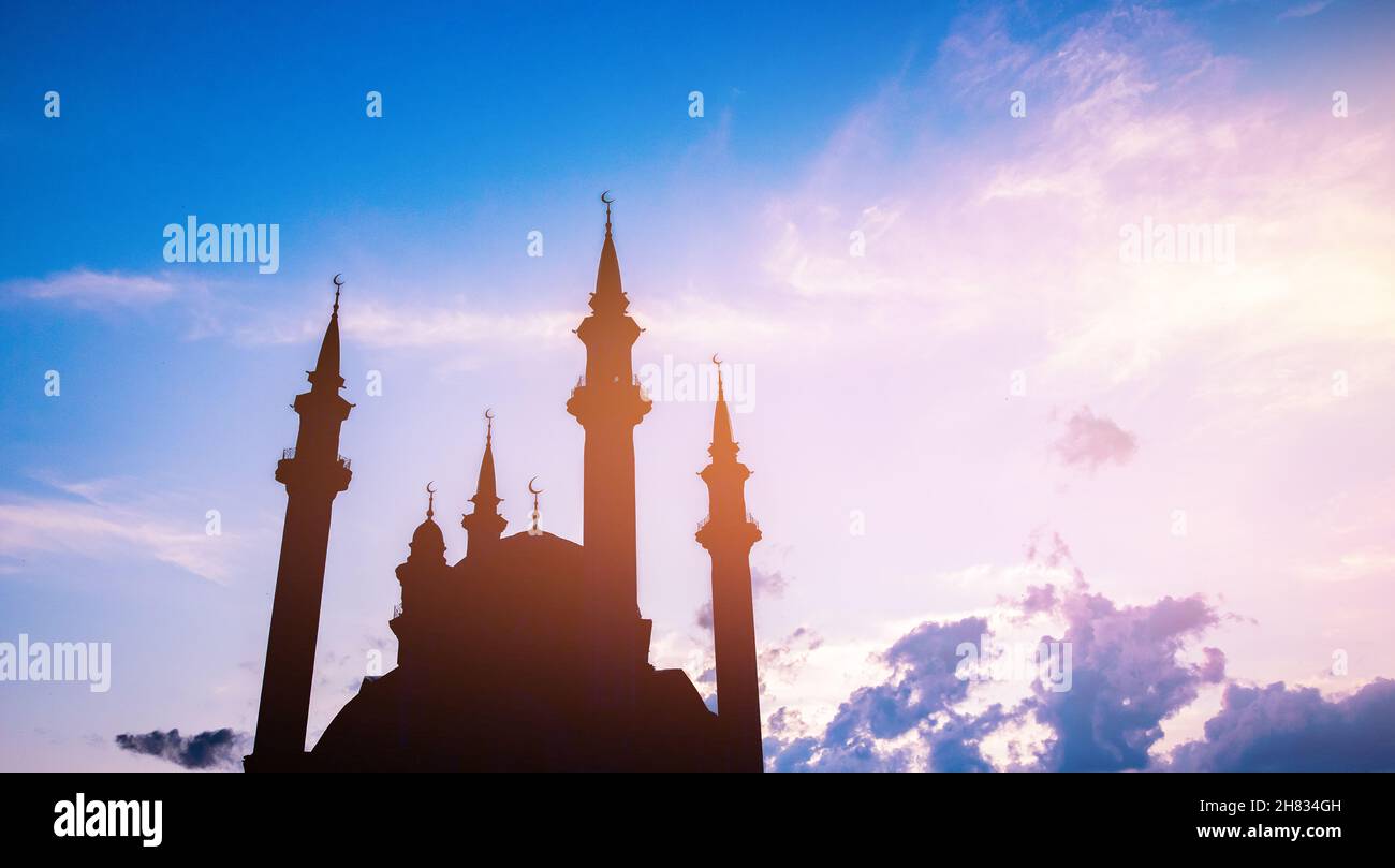 Bella silhouette banner moschea islamica nube al tramonto con luce solare. Foto Stock
