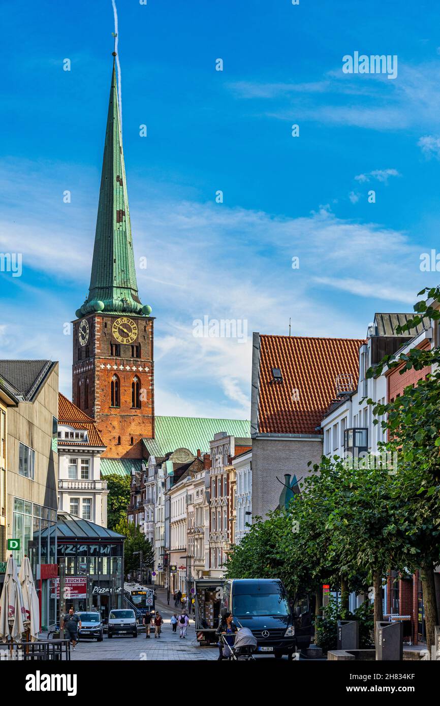 Il campanile della chiesa di San-Jakobi-Kirche, con la sua guglia verde, domina le strade e gli edifici di Lübeck. Lubecca, Germania Foto Stock