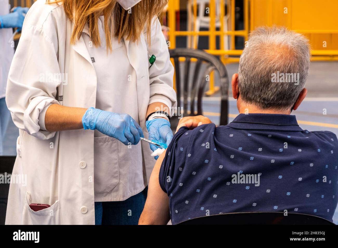 Valencia, Spagna; 6 aprile 2021: L'operatore sanitario inietta il vaccino anticovida ad un paziente presso un centro di vaccinazione. Vaccinazione anticovideo ca Foto Stock