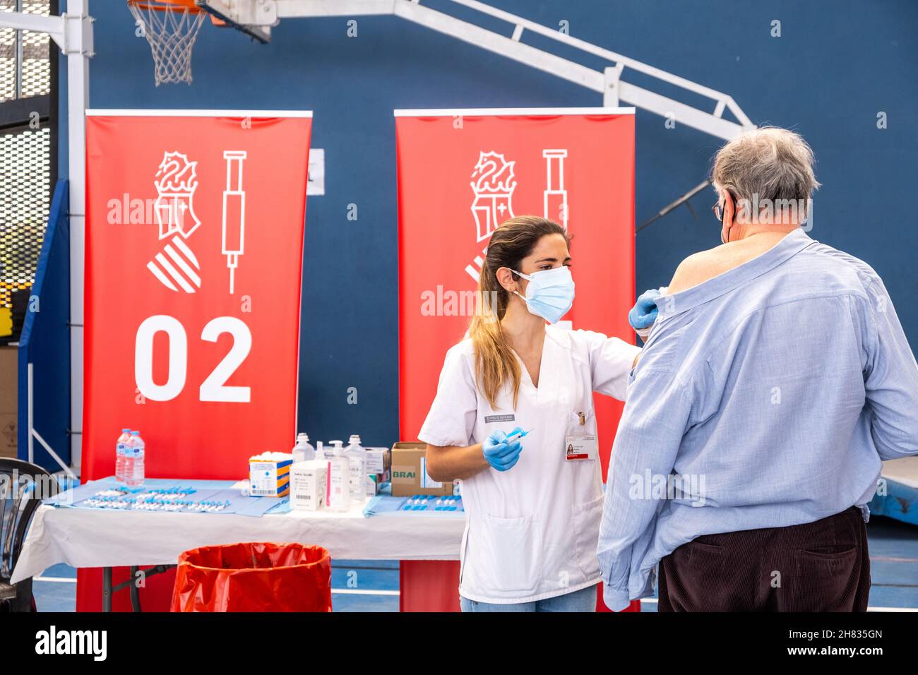 Valencia, Spagna; 6 aprile 2021: L'operatore sanitario inietta il vaccino anticovida ad un paziente presso un centro di vaccinazione. Foto Stock