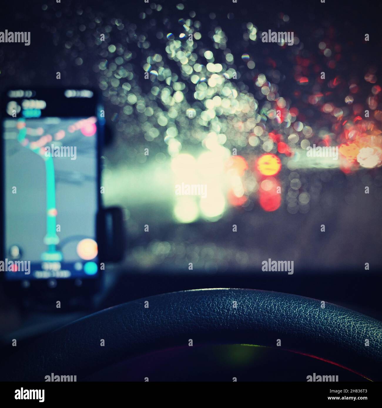 Stagione invernale pericolosa con neve su strada. L'interno dell'auto dal punto di vista del conducente - pericoloso traffico serale in cattive condizioni meteorologiche. Foto Stock