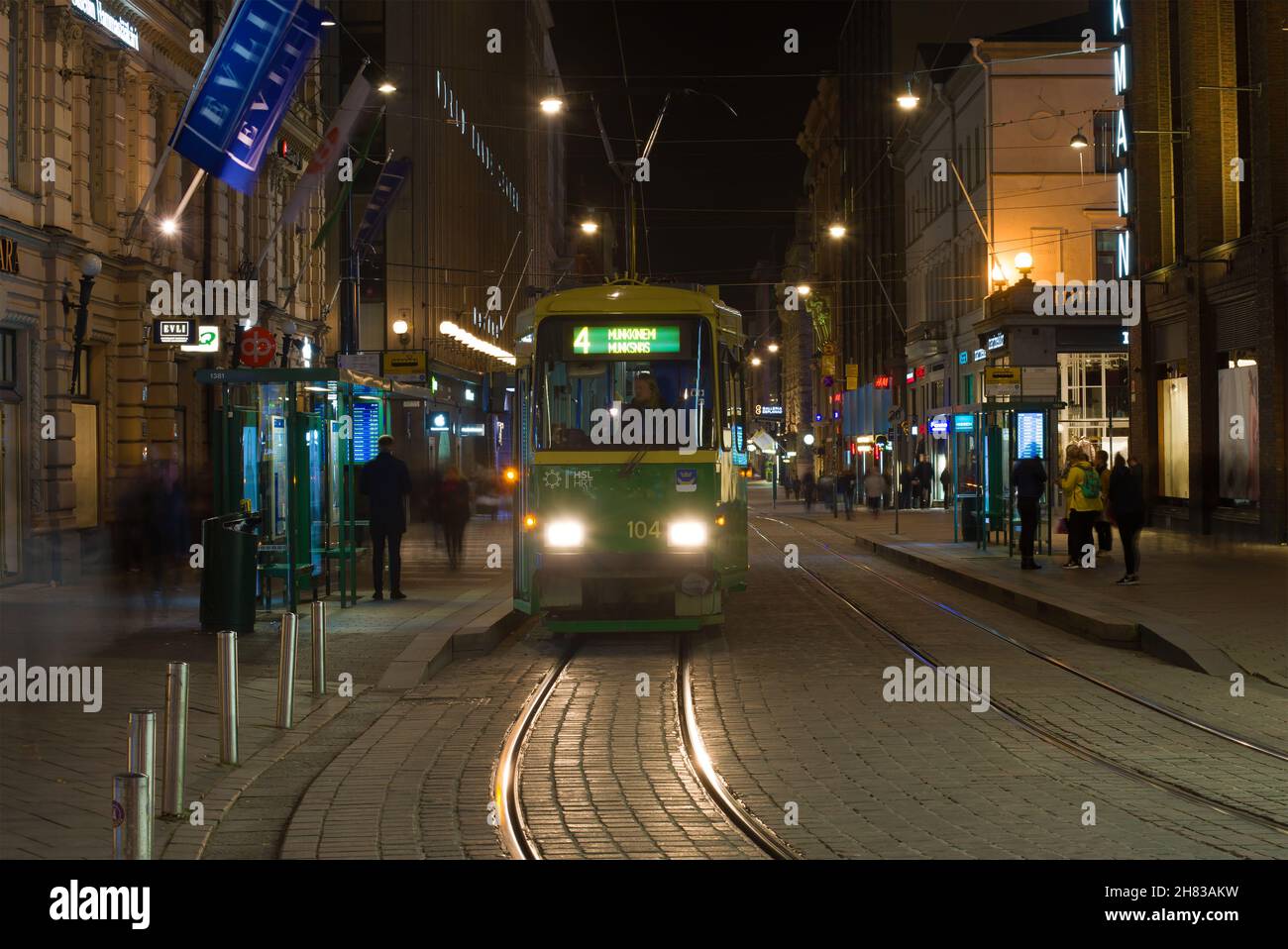 HELSINKI, FINLANDIA - 30 SETTEMBRE 2017: Tram a una fermata su una strada notturna Foto Stock