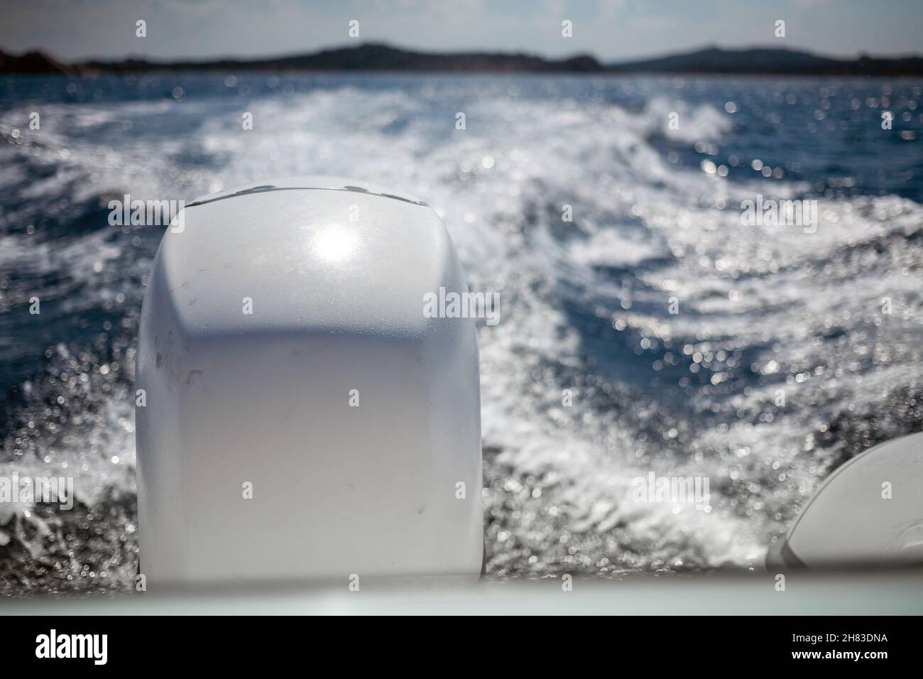 Primo piano del motore di motoscafo durante il viaggio sulla bellissima acqua di mare blu. Percorso schiuma, le barche si svegliano, in acqua di mare. Foto Stock