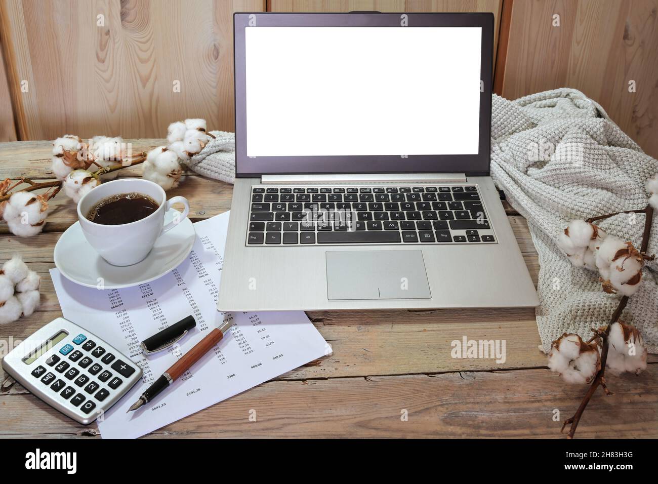 contabilità stagionale autunno, computer portatile con schermo bianco mock up, calcolatrice, documento finanziario e una tazza di caffè su un rustico tavolo in legno con cotone branc Foto Stock