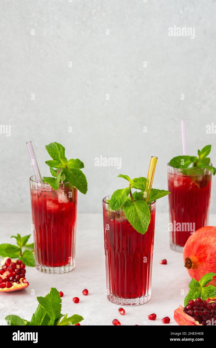 Rinfrescante succo di melograno in bicchieri con paglia di menta e vetro, bevanda fredda Foto Stock