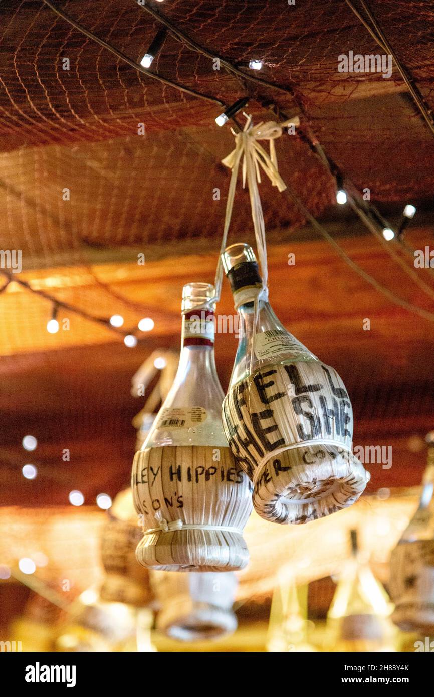 Bottiglie di alcol appese al soffitto al ristorante di pesce Mermaid, St Ives, Cornovaglia, Regno Unito Foto Stock