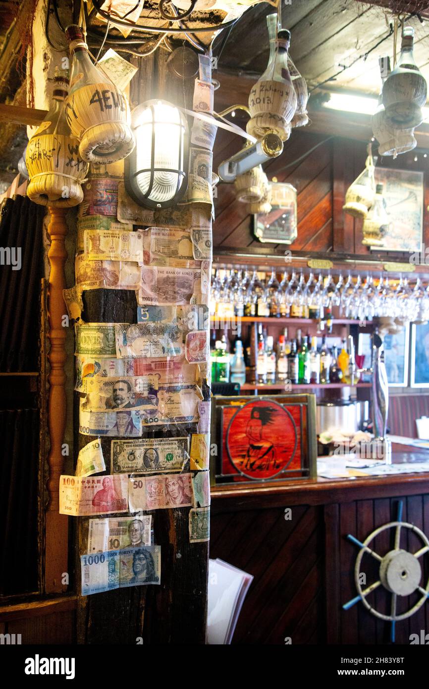 Muro coperto con banconote e bar in valuta estera all'interno del ristorante a tema nautico Mermaid Seafood, St Ives, Cornovaglia, Regno Unito Foto Stock